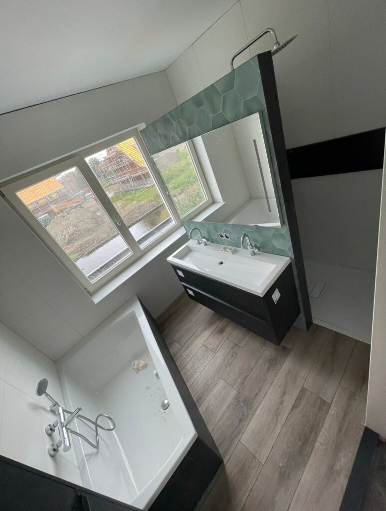 Ligbad en dubbele wastafel in de badkamer in Boskoop