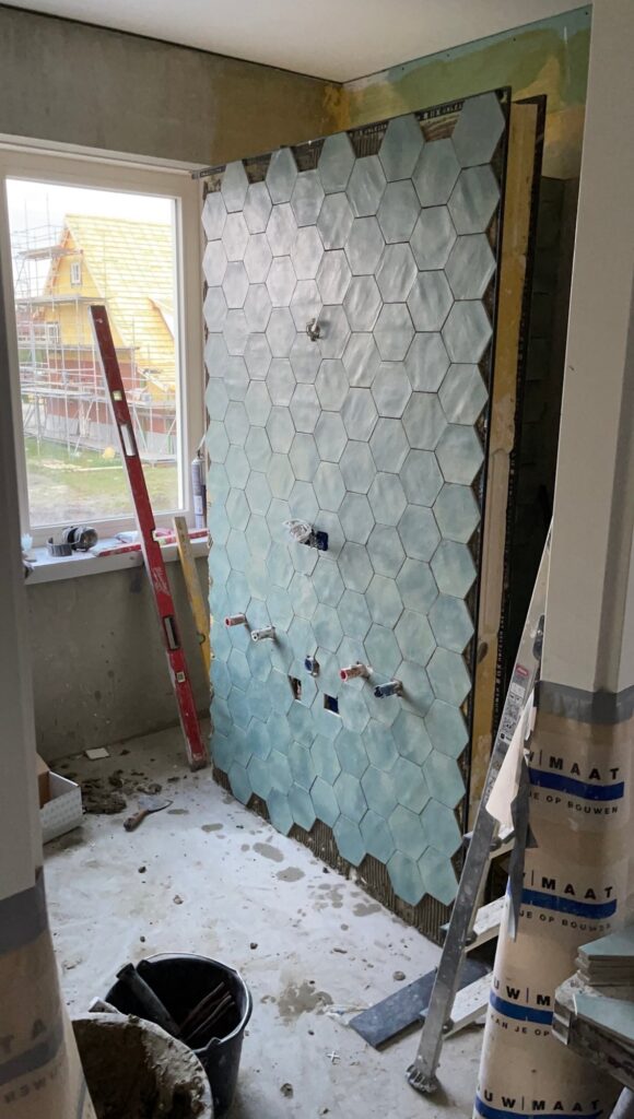Douchewand met hexagontegels in Boskoop tijdens de bouw
