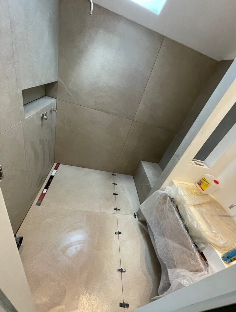 Badkamer in Pijnacker met tegels van 120 x 120 en Velux-dakraam